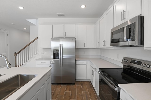 kitchen featuring stainless steel appliances, white cabinetry, and sink