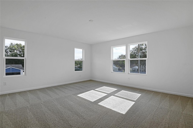 carpeted spare room featuring plenty of natural light