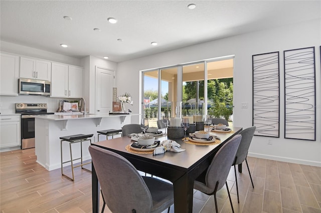 500 Summit River Dr, Apopka, FL 32712 - dining area featuring recessed lighting, a textured ceiling, baseboards, and wood tiled floor