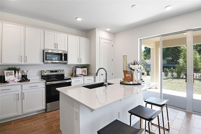 500 Summit River Dr, Apopka, FL 32712 - kitchen featuring light countertops, a breakfast bar area, a sink, an island with sink, and appliances with stainless steel finishes