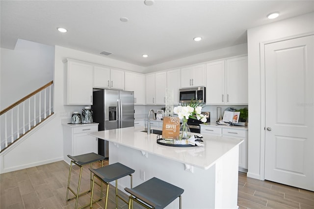 500 Summit River Dr, Apopka, FL 32712 - kitchen featuring white cabinetry, light countertops, stainless steel appliances, a breakfast bar, and visible vents