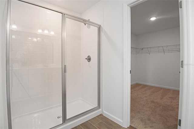 500 Summit River Dr, Apopka, FL 32712 - bathroom featuring a spacious closet, a stall shower, baseboards, and wood finished floors