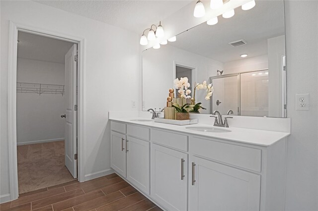 500 Summit River Dr, Apopka, FL 32712 - bathroom with a shower stall, wood tiled floor, visible vents, and a sink