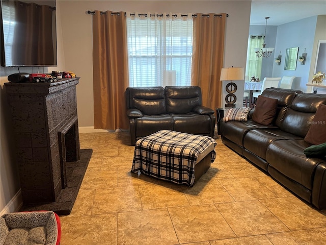 tiled living room featuring a tile fireplace and a chandelier