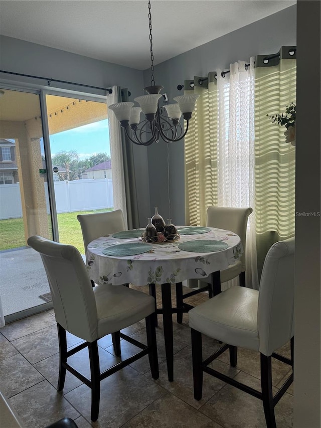 dining space with an inviting chandelier and tile patterned floors