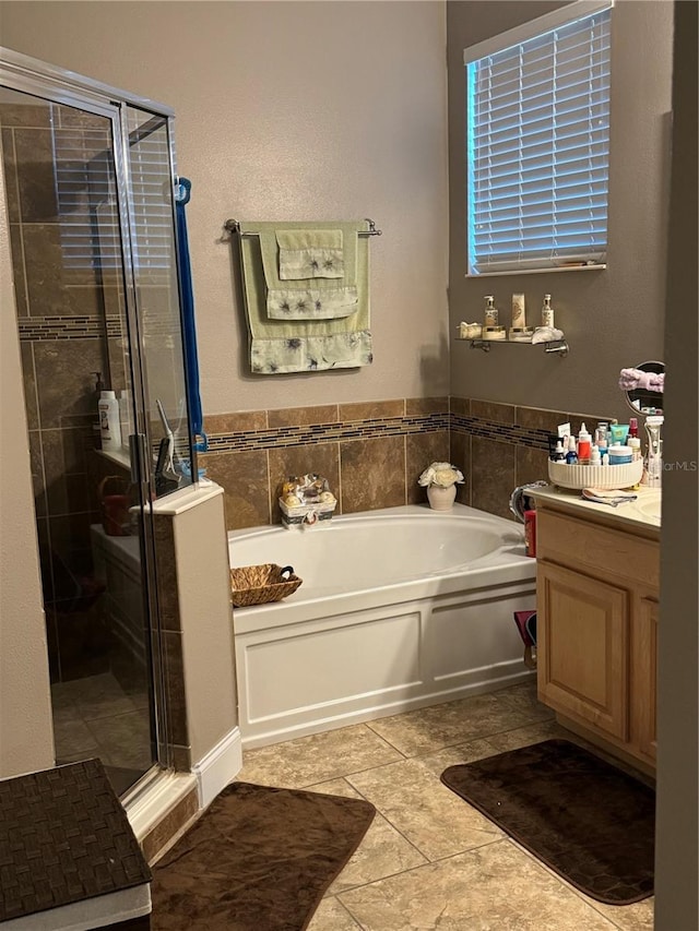 bathroom with plus walk in shower, tile patterned flooring, and vanity