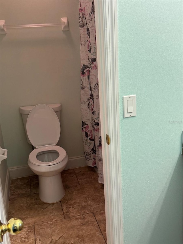 bathroom featuring curtained shower and toilet