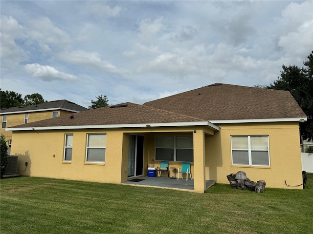 rear view of house with a lawn, central AC, and a patio area