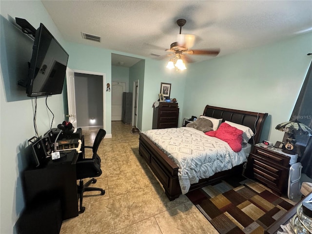 tiled bedroom featuring a textured ceiling and ceiling fan