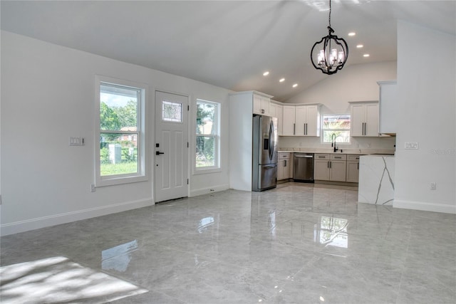 foyer featuring a wealth of natural light, vaulted ceiling, sink, and a chandelier