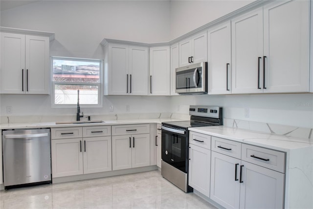 kitchen featuring light stone counters, stainless steel appliances, sink, and light tile patterned flooring