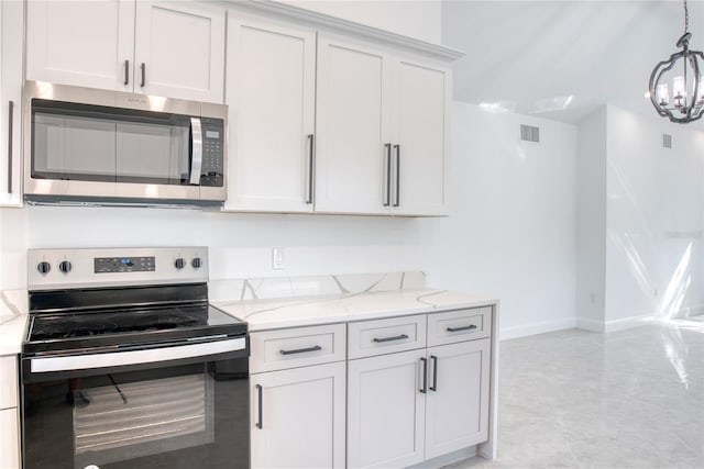 kitchen with light stone counters, stainless steel appliances, a notable chandelier, white cabinetry, and pendant lighting