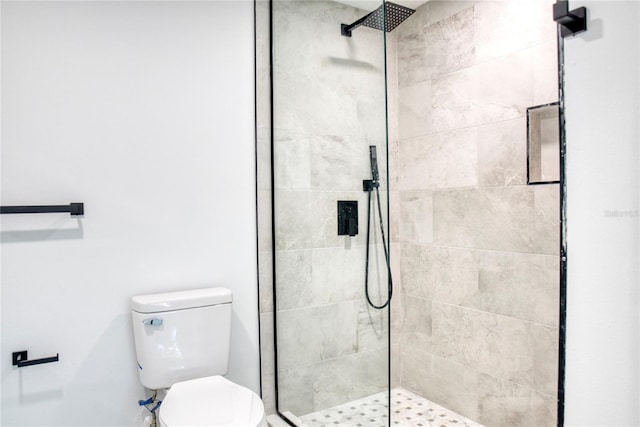 bathroom featuring toilet and a shower with shower door