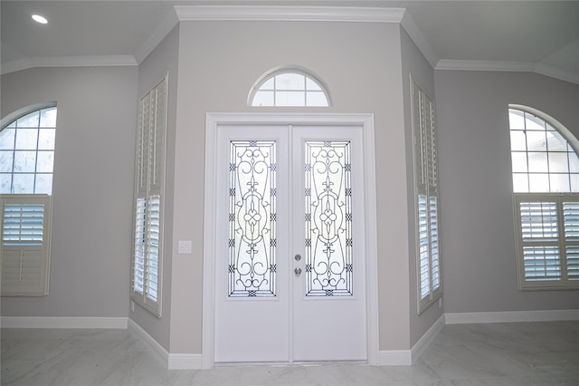 entrance foyer with french doors, lofted ceiling, and crown molding