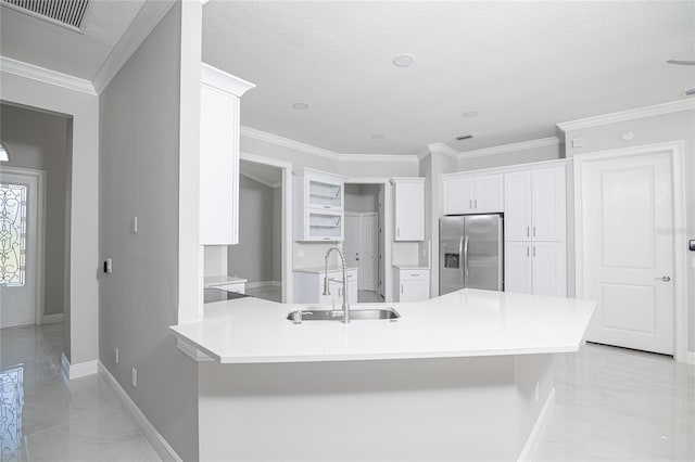 kitchen with a textured ceiling, stainless steel fridge with ice dispenser, sink, white cabinetry, and ornamental molding