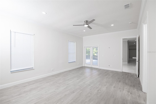 empty room featuring ceiling fan, a textured ceiling, light wood-type flooring, and ornamental molding