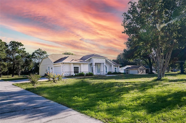 ranch-style home with a garage and a lawn