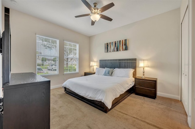 carpeted bedroom featuring ceiling fan and a closet