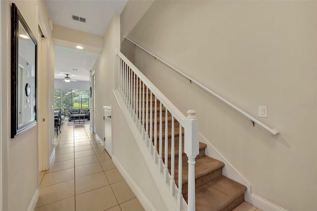 stairway with ceiling fan and tile patterned floors