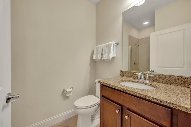 bathroom featuring tile patterned flooring, vanity, toilet, and walk in shower