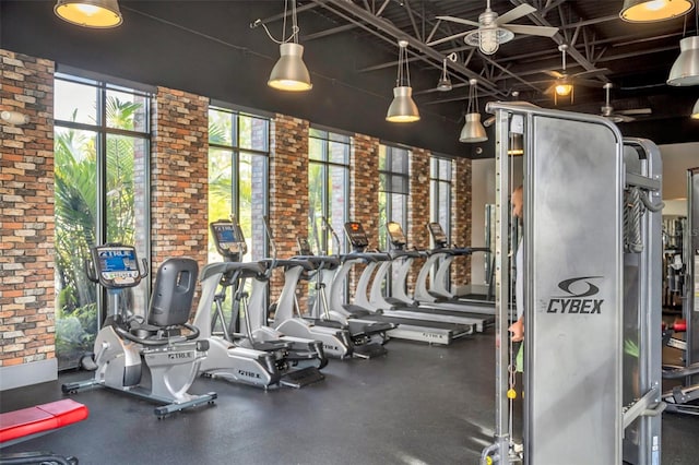 workout area featuring brick wall and ceiling fan