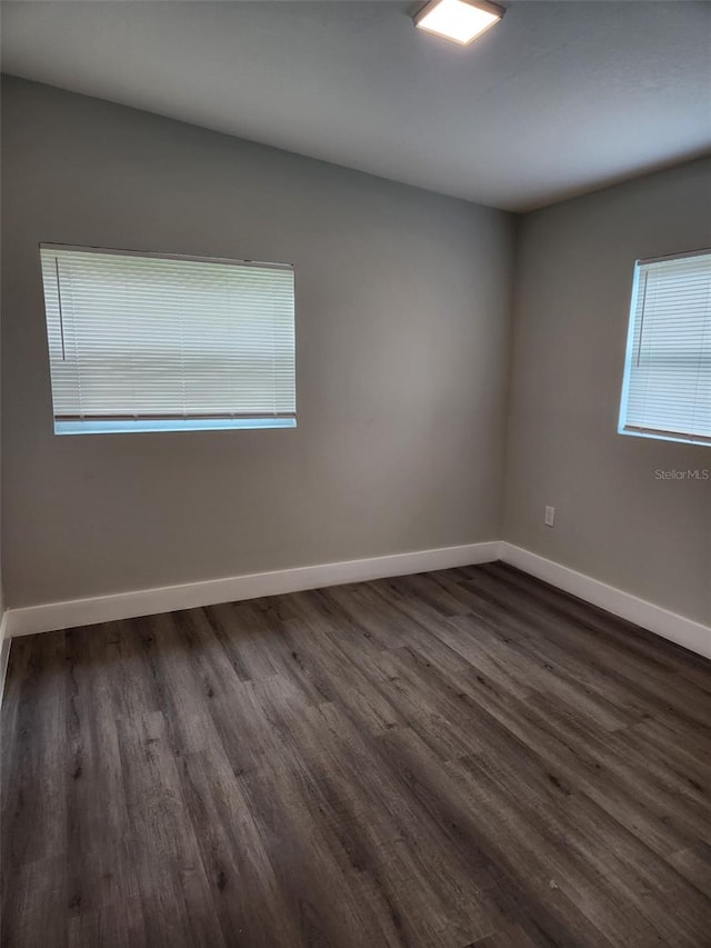 unfurnished room with dark wood-type flooring and a wealth of natural light