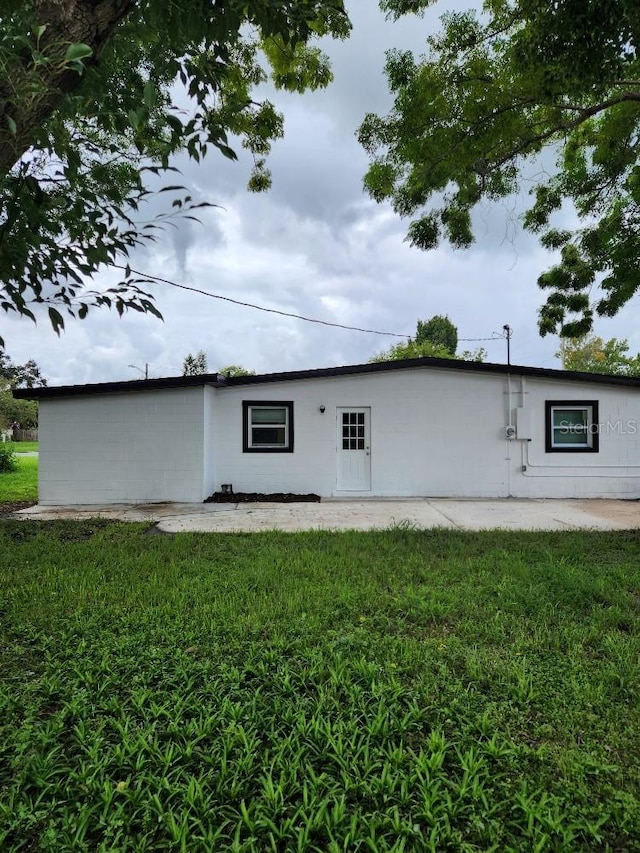 rear view of property with a yard and a patio area