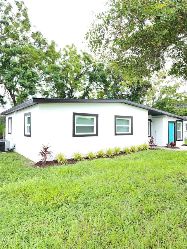 view of front facade with a front lawn and central AC unit