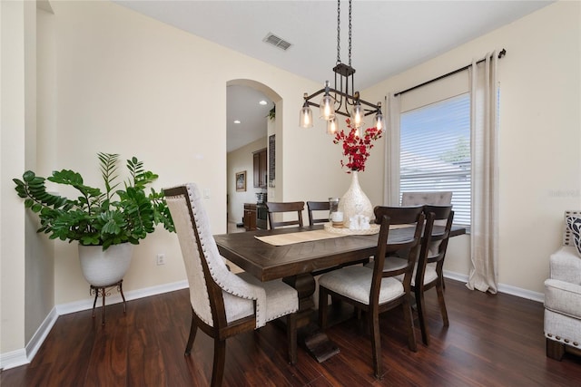 dining room with dark hardwood / wood-style flooring and a notable chandelier