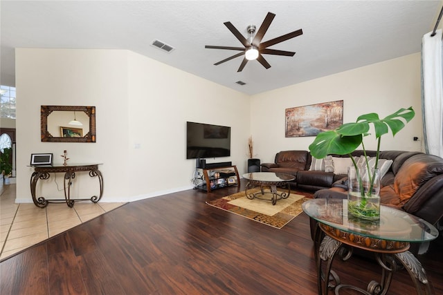 living room with light wood-type flooring, ceiling fan, a textured ceiling, and vaulted ceiling