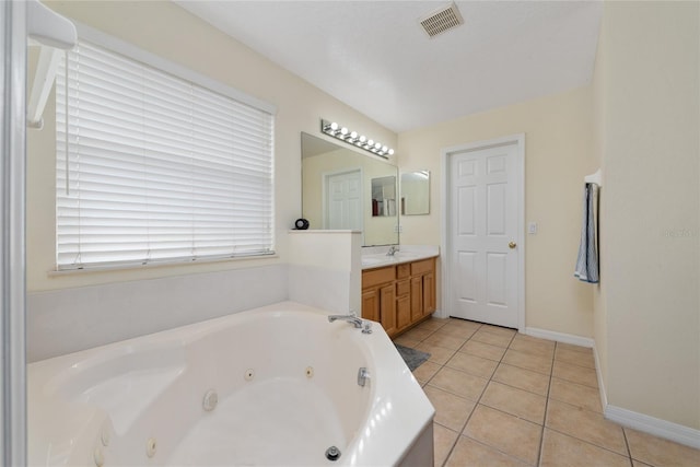 bathroom featuring tile patterned flooring, a tub to relax in, and vanity