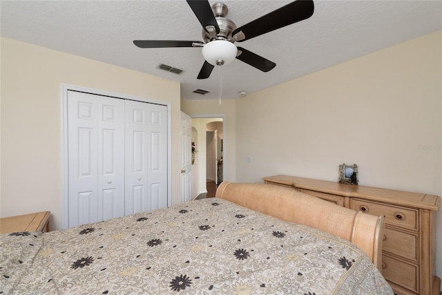 bedroom with a closet, ceiling fan, and a textured ceiling