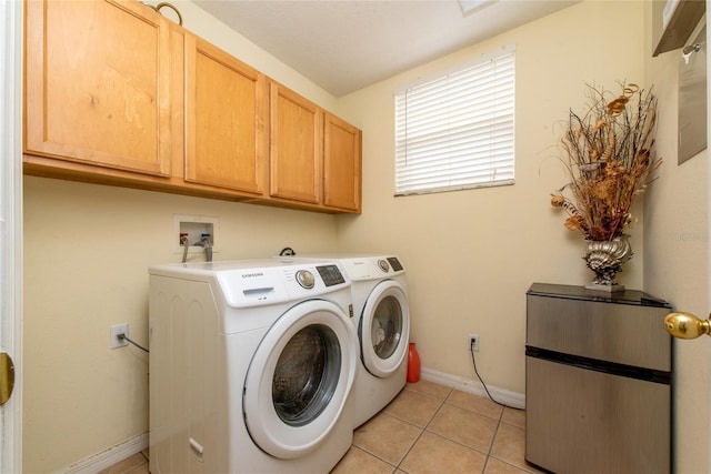 laundry room with light tile patterned flooring, cabinets, and separate washer and dryer