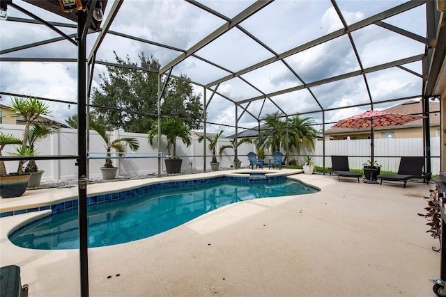 view of pool with glass enclosure and a patio area