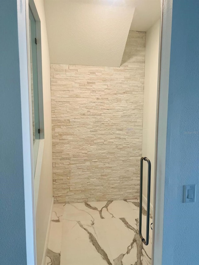 bathroom with a shower with door