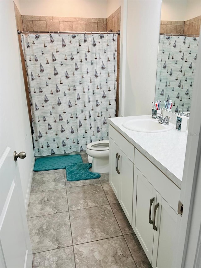 bathroom featuring curtained shower, toilet, and vanity