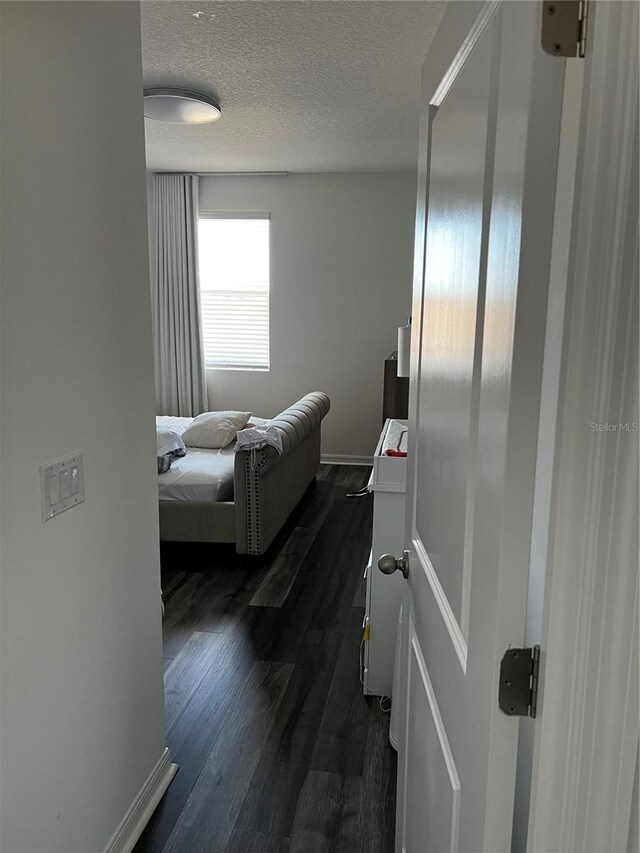 bedroom featuring a textured ceiling and dark wood-type flooring