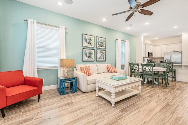 living room with ceiling fan and light wood-type flooring