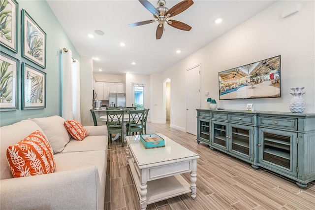 living room featuring ceiling fan and light hardwood / wood-style flooring