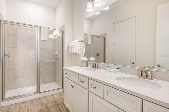 bathroom featuring wood-type flooring, an enclosed shower, and vanity