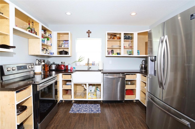 kitchen with a sink, appliances with stainless steel finishes, dark wood-style floors, open shelves, and dark countertops