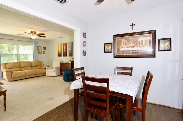 dining area featuring a ceiling fan, visible vents, and dark wood-style flooring