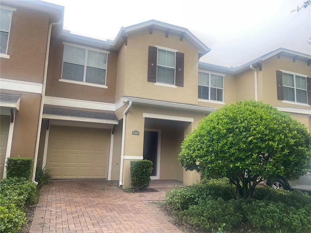 multi unit property featuring an AC wall unit and a garage