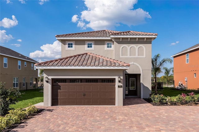 mediterranean / spanish-style home featuring a front yard and a garage