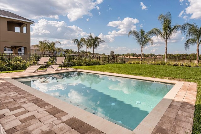 view of pool with a lawn and a patio