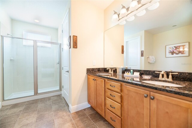 bathroom featuring vanity, a shower with shower door, and tile patterned floors