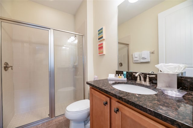 bathroom featuring a shower with shower door, tile patterned flooring, toilet, and vanity