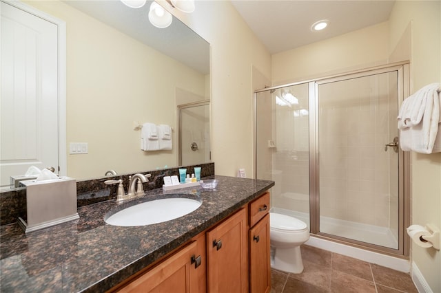 bathroom featuring vanity, toilet, an enclosed shower, and tile patterned floors