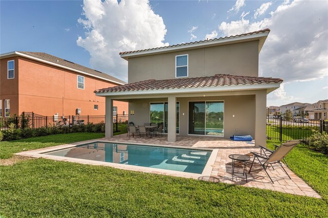 back of house with a fenced in pool, a yard, and a patio area