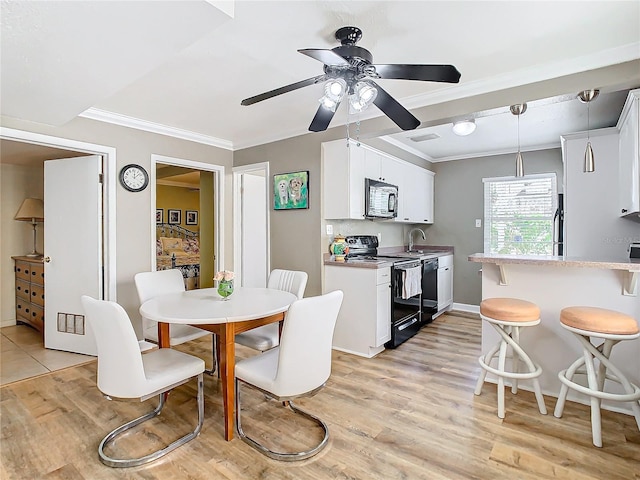 dining room featuring light wood-type flooring, crown molding, and ceiling fan